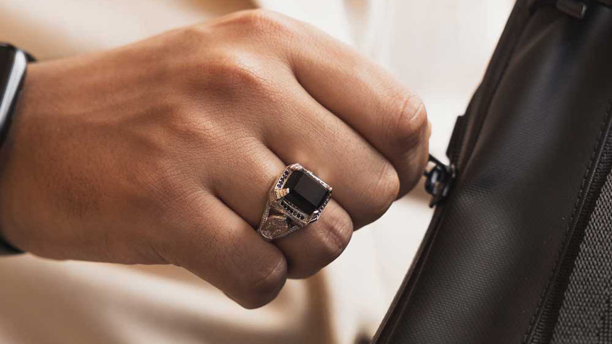 man wearing black onyx ring for men on ring finger with intricate sterling silver details